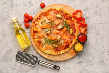 Assiette avec pizza aux fruits de mer savoureux, râpe et ingrédients sur fond de grunge
