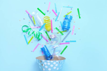 Téléchargez les photos : Cône de fête avec confettis et serpentine sur fond bleu. Célébration Journée des enfants - en image libre de droit