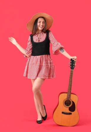 Téléchargez les photos : Jeune femme avec guitare sur fond rouge. Fête Junina (Festival de juin) - en image libre de droit