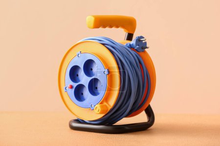Photo for Extension electric cable reel near color wall - Royalty Free Image