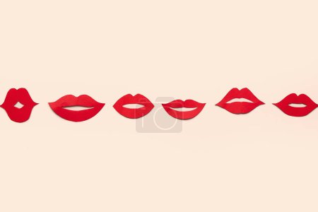 Téléchargez les photos : Lèvres en papier rouge sur fond beige - en image libre de droit