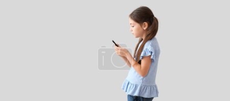 Kleines Mädchen mit schlechter Körperhaltung mit Handy auf hellem Hintergrund