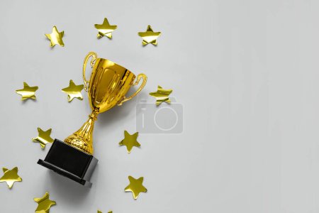 Gold cup with stars on grey background