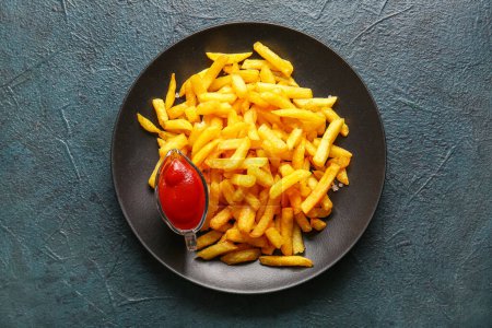 Photo for Plate with tasty french fries and ketchup on dark color background - Royalty Free Image