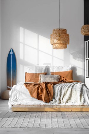 Intérieur de la chambre moderne avec planche de surf et grand lit