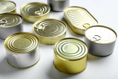 Assortment of tin cans with fish on white background