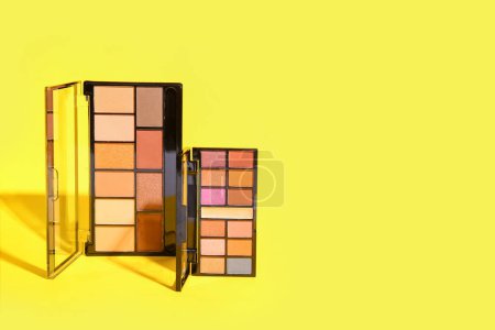 Photo for Palettes of eyeshadows on yellow background - Royalty Free Image
