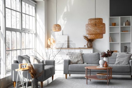 Foto de Interior de luminoso salón con sofás grises y jarrones en la mesa de café - Imagen libre de derechos