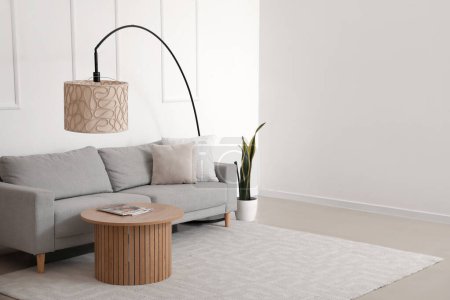 Téléchargez les photos : Intérieur du salon moderne avec canapé gris confortable, table basse et lampe - en image libre de droit