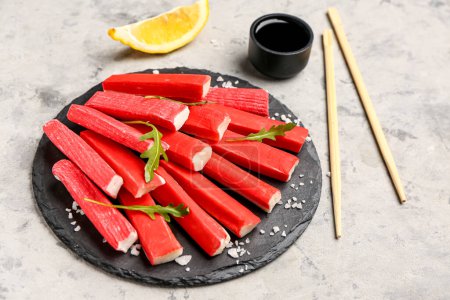Photo for Slate board with tasty crab sticks on grunge background - Royalty Free Image