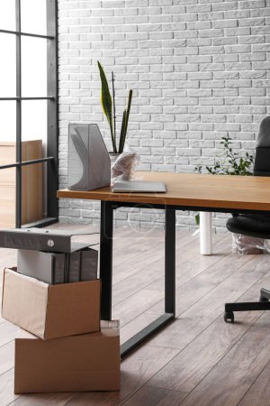 Photo for Workplace with cardboard boxes in office on moving day - Royalty Free Image