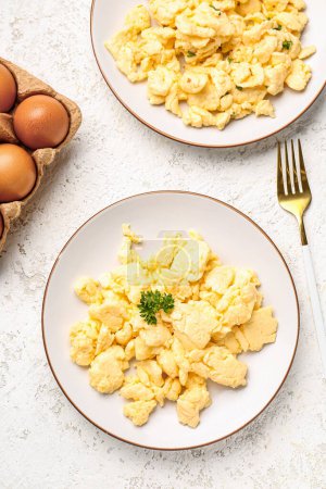 Photo for Composition with plates of scrambled eggs on light textured background - Royalty Free Image
