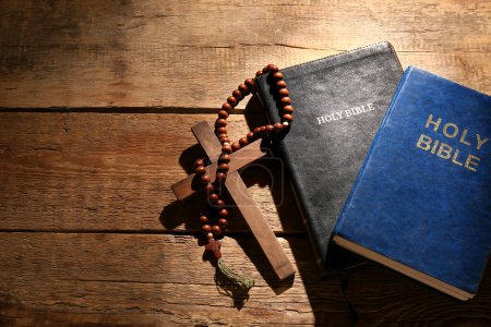 Téléchargez les photos : Bibles saintes avec des perles de prière et croix sur fond en bois - en image libre de droit