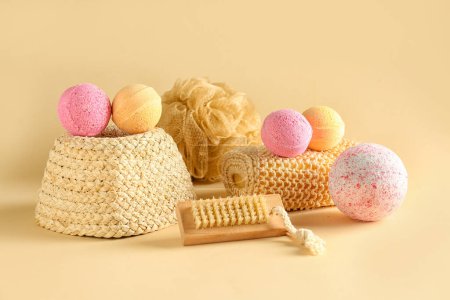 Foto de Bombas de baño con cepillo de masaje y esponjas sobre fondo beige - Imagen libre de derechos