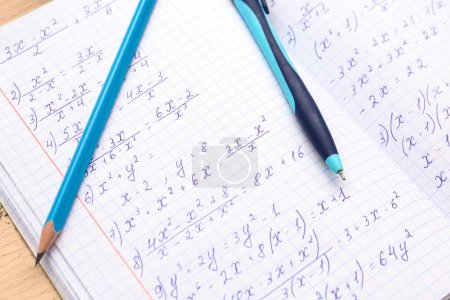 Foto de Copybook con fórmulas matemáticas, pluma y lápiz, primer plano - Imagen libre de derechos