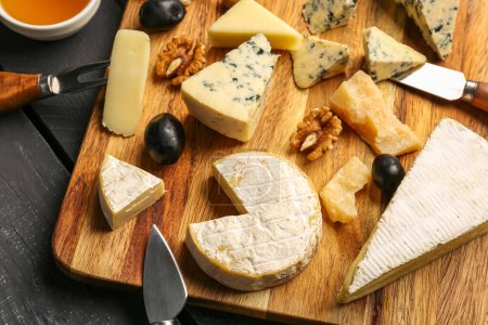 Téléchargez les photos : Plateau en bois avec différents types de fromage savoureux sur la table, gros plan - en image libre de droit