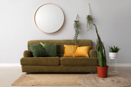 Foto de Interior de la moderna sala de estar con sofá acogedor, cactus grande y plantas de interior - Imagen libre de derechos