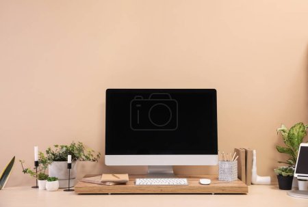 Téléchargez les photos : Lieu de travail moderne avec ordinateur et plantes d'intérieur près du mur beige - en image libre de droit