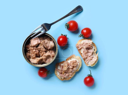 Photo for Delicious tuna bruschettas, tin can and tomatoes on blue background - Royalty Free Image