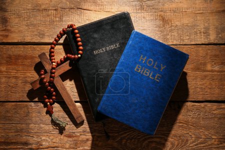 Foto de Santas Biblias con cuentas de oración y cruz sobre fondo de madera - Imagen libre de derechos