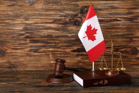 Flagge von Kanada, Richtergabel, Justizwaage und Gesetzbuch auf Holzgrund