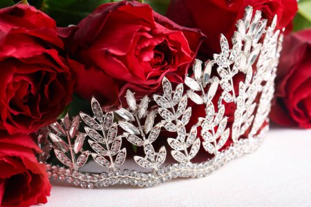 Beautiful tiara with roses on white table, closeup. Prom concept