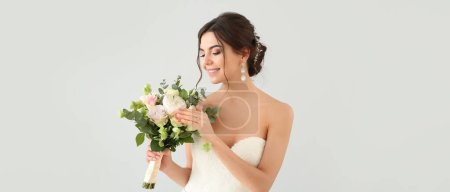 Foto de Hermosa novia joven con ramo de flores sobre fondo claro - Imagen libre de derechos