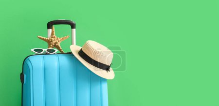 Téléchargez les photos : Valise avec accessoires de plage sur fond vert avec espace pour le texte - en image libre de droit