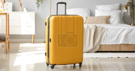 Téléchargez les photos : Valise jaune dans la chambre d'hôtel. Concept de voyage - en image libre de droit