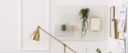 Photo for Hanging pegboard with houseplant, notebook and decor in interior of light room - Royalty Free Image