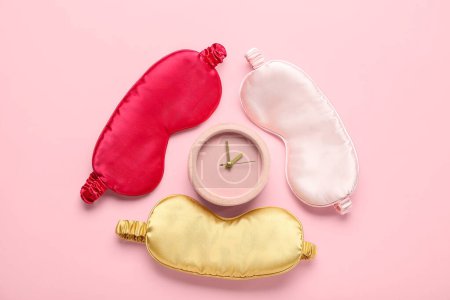 Photo for Sleeping masks and alarm clock on pink background - Royalty Free Image