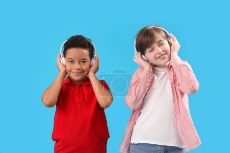 Little boys in headphones on blue background. Children's Day celebration