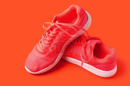 Foto de Par de elegantes zapatillas de deporte femeninas sobre fondo de color - Imagen libre de derechos