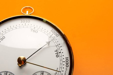 Aneroid Barometer auf orangefarbenem Hintergrund