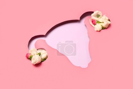 Cut pink paper in shape of uterus with roses on lilac background