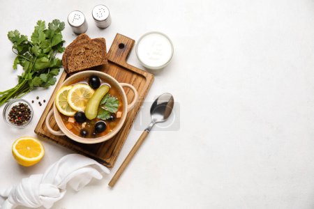 Téléchargez les photos : Pot de soupe Hodgepodge savoureuse avec du pain et de la crème sure sur fond clair - en image libre de droit