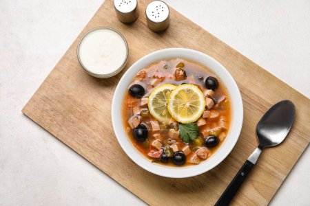 Téléchargez les photos : Bol de soupe Hodgepodge savoureuse avec crème sure sur fond clair - en image libre de droit