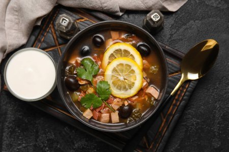 Téléchargez les photos : Bol de soupe Hodgepodge savoureuse avec crème sure sur fond sombre - en image libre de droit