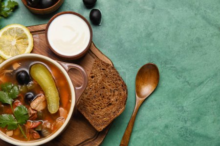 Téléchargez les photos : Pot de soupe Hodgepodge savoureuse avec crème sure et pain sur fond grunge - en image libre de droit