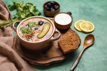 Téléchargez les photos : Pot de soupe Hodgepodge savoureuse avec crème sure et pain sur fond grunge - en image libre de droit