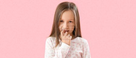 Foto de Little girl biting nails on pink background - Imagen libre de derechos