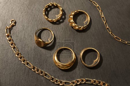 Beautiful rings and chain necklace on black background