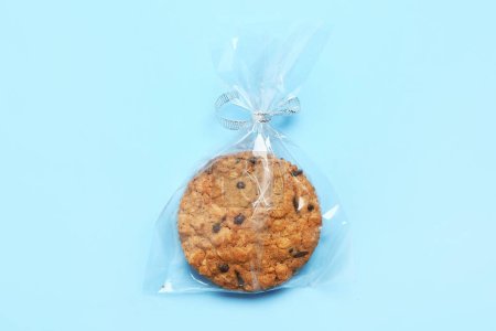 Tasty biscotti cookie in bag on blue background