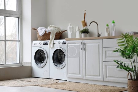 Foto de Interior del lavadero con lavadoras y ropa sucia - Imagen libre de derechos