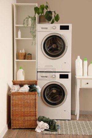 Photo for Interior of laundry room with washing machines, table and basket - Royalty Free Image