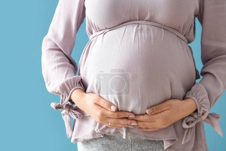Photo for Young pregnant woman on blue background, closeup - Royalty Free Image