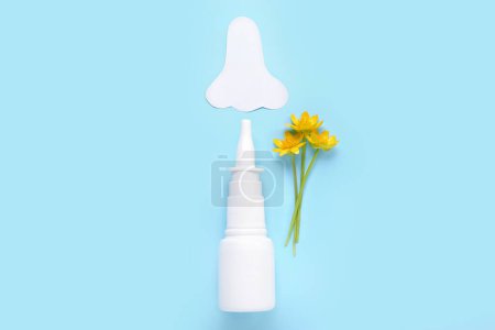 Photo for Bottle of drops with paper nose and flowers on blue background. Seasonal allergy concept - Royalty Free Image
