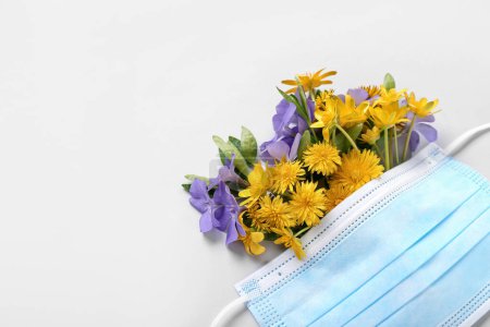 Photo for Medical mask with flowers on light background, closeup. Seasonal allergy concept - Royalty Free Image