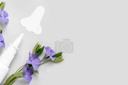 Photo for Bottle of drops with paper nose and flowers on light background, closeup. Seasonal allergy concept - Royalty Free Image