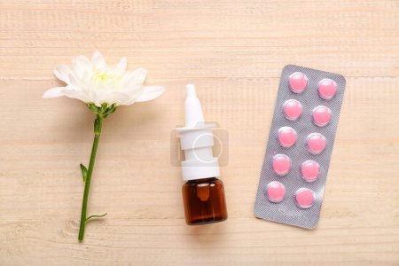 Photo for Nasal drops with flower and pills on light wooden background. Seasonal allergy concept - Royalty Free Image